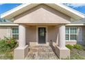 Inviting front entrance with decorative glass door, stone tile landing and columned porch at 14085 Sw 34Th Terrace Rd, Ocala, FL 34473