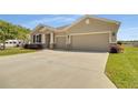 A beautiful home with three-car garage, a wide driveway, and colorful landscaping at 5198 Ne 19Th Pl, Ocala, FL 34470