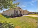 A home showcasing a vibrant lawn, neat landscaping, and a welcoming three-car garage at 5198 Ne 19Th Pl, Ocala, FL 34470