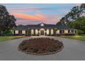 Charming home with a circular driveway highlighted by a colorful sunset at 5484 Sw 30Th Ave, Ocala, FL 34471