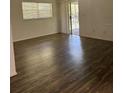 Bright living room features wood floors, neutral walls, large windows, and sliding door access to patio at 571 Midway Trak # J202, Ocala, FL 34472