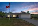 Charming one-story home with manicured lawn and two-car garage, under a beautiful sunset sky at 5899 Pecan Rd, Ocala, FL 34472