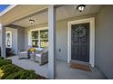 Inviting front porch with gray decor, including a 'Welcome' mat and decorative wreath on the door at 5899 Pecan Rd, Ocala, FL 34472