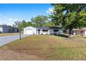 Well-maintained single-story home with an attached garage and a green lawn, offering a welcoming curb appeal at 614 Third Ave, Lady Lake, FL 32159