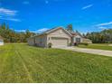 Spacious home with a two-car garage and a lush green lawn at 716 Hickory Course Loop, Ocala, FL 34472