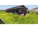 Spacious backyard features a screened-in pool, lush green lawn, and privacy fence for outdoor enjoyment at 8875 Sw 58Th Street Rd, Ocala, FL 34481