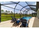 Inviting screened-in pool area with comfortable seating and serene views of the lush green backyard at 8875 Sw 58Th Street Rd, Ocala, FL 34481