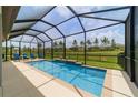 Relaxing screened-in pool with waterfall feature offers a private oasis for outdoor enjoyment and entertaining at 8875 Sw 58Th Street Rd, Ocala, FL 34481