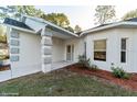 Inviting front entrance with covered porch, grey accent decor, and manicured landscaping at 9525 Sw 53Rd Cir, Ocala, FL 34476