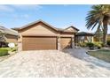 Lovely home showcasing a three-car garage, a brick-paved driveway and meticulous landscaping at 9532 Sw 70Th Loop, Ocala, FL 34481