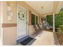 Inviting front porch with seating, decorative wreath, and neutral tones creating a warm welcome at 9638 Sw 94Th Ave # C, Ocala, FL 34481