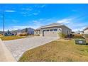 Exterior view of a house with a stone driveway, well-maintained lawn, and a two-car garage at 10589 Sw 98Th Ln, Ocala, FL 34481