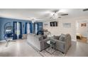 Spacious living room with blue accent wall, neutral furnishings, tile flooring, and views into adjacent rooms at 1081 Se 170Th Ave, Silver Springs, FL 34488