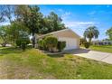 Exterior side view of a single-story home with a lush lawn and trimmed shrubbery at 10833 Sw 86Th Ter, Ocala, FL 34481