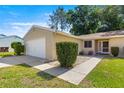 Front exterior view of a single-story home with a two-car garage and meticulous landscaping at 10833 Sw 86Th Ter, Ocala, FL 34481