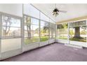 Enclosed porch featuring a ceiling fan and multiple windows offering bright natural light at 10833 Sw 86Th Ter, Ocala, FL 34481