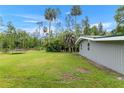 Large backyard with lush grass, bordered by mature trees offering privacy at 11065 Ne 42Nd St, Silver Springs, FL 34488
