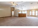 Expansive living room featuring a beamed ceiling, ample natural light, and neutral carpeting, perfect for entertaining at 13645 Se 42 Ave, Summerfield, FL 34491
