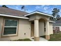 Inviting front entrance with an arched porchway and beige stucco exterior at 15976 Sw 23Rd Court Rd, Ocala, FL 34473