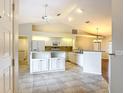 Open kitchen featuring white cabinetry, tile flooring, granite countertops, and stainless steel appliances at 5327 Sw 89Th St, Ocala, FL 34476