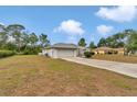 Wide shot of the property featuring a long concrete driveway and two-car garage at 5331 Old Hickory Ln, Fruitland Park, FL 34731