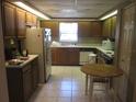 Cozy kitchen with wood cabinets, white appliances, and a breakfast table, perfect for casual dining at 5355 Sw 31St St, Ocala, FL 34474