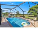 Relaxing screened-in pool area with a waterfall feature and a view of the spacious backyard at 719 Ne 39Th St, Ocala, FL 34479