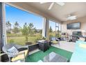 Screened in patio with cozy seating and view of the green backyard at 8090 Penrose Pl, Wildwood, FL 34785