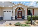 Close up of the front entrance showcasing the arched entryway, sidelights, and decorative front door at 8955 Sw 86Th Loop, Ocala, FL 34481