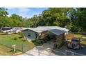 Single-story home featuring mature landscaping, an inviting carport, and a secure fenced-in yard at 1039 Ne 25Th St, Ocala, FL 34470