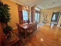 Elegant dining room featuring wood floors, a chandelier, and a table set for dinner at 12453 Se 93Rd Court Rd, Summerfield, FL 34491