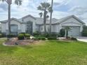 Charming single-story home with manicured lawn and mature landscaping, including palm trees at 12453 Se 93Rd Court Rd, Summerfield, FL 34491