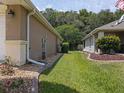 Well-maintained side yard featuring a manicured lawn, rock garden and mature trees, perfect for privacy at 13196 Se 86Th Cir, Summerfield, FL 34491