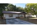 Single-story home with stone accents, a driveway, and mature trees at 16 Water Trak, Ocala, FL 34472