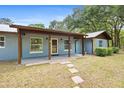 Inviting single-story home featuring a covered porch, stone walkway, and well-maintained landscaping at 19300 Sw 60Th St, Dunnellon, FL 34432