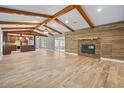 Open-concept living room featuring a modern fireplace, wood-look tile flooring, and easy access to the kitchen at 19300 Sw 60Th St, Dunnellon, FL 34432