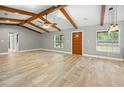 Bright living room boasting beautiful wood-look tile floors, wooden ceiling beams, and a warm, welcoming atmosphere at 19300 Sw 60Th St, Dunnellon, FL 34432
