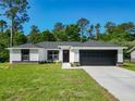 Single-story home with modern design elements, dark accents, and well-maintained landscaping at 2376 Se 40Th Street Road, Ocala, FL 34480