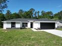 Charming single-story home featuring a modern design, black accents, fresh lawn, and a two-car garage at 2376 Se 40Th Street Road, Ocala, FL 34480