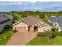 Well-maintained single-story home with a brick driveway, two-car garage, and mature landscaping, nestled in a golf community at 3587 Nw 55Th Cir, Ocala, FL 34482