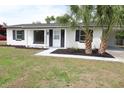 Charming single-story home featuring an open carport, contrasted by fresh plantings and black window shutters at 3807 Sw 143Rd Lane Rd, Ocala, FL 34473