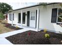 Inviting front porch showcasing fresh mulch, colorful flowers, and a freshly painted walkway and posts at 3807 Sw 143Rd Lane Rd, Ocala, FL 34473