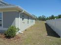 Side view of home with white vinyl fence and well maintained yard at 4373 Ne 31St St, Ocala, FL 34470