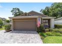 Single car garage with brick-paved driveway and tidy landscaping at 4404 Ne 4Th St, Ocala, FL 34470