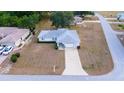 Aerial view of a well-maintained home with a two-car garage and large driveway in a serene neighborhood at 6150 Sw 103Rd Loop, Ocala, FL 34476