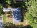 Aerial view showcases the home's roof, driveway, and surrounding trees, providing a sense of privacy at 6432 Nw 64Th Ter, Ocala, FL 34482
