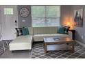 Bright living room features a white leather sofa, stylish rug, and decor at 6432 Nw 64Th Ter, Ocala, FL 34482