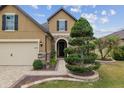 Home's facade with stone archway, manicured shrubs, and paver walkway enhance this house's curb appeal at 6816 Sw 95Th Cir, Ocala, FL 34481