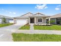 Beautiful one-story home with a manicured lawn, a two-car garage, and a welcoming covered porch at 7827 Sw 56Th Pl, Ocala, FL 34474