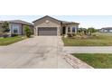Charming home showcasing a driveway leading to a two-car garage and manicured front yard at 9063 Sw 59Th Lane Rd, Ocala, FL 34481